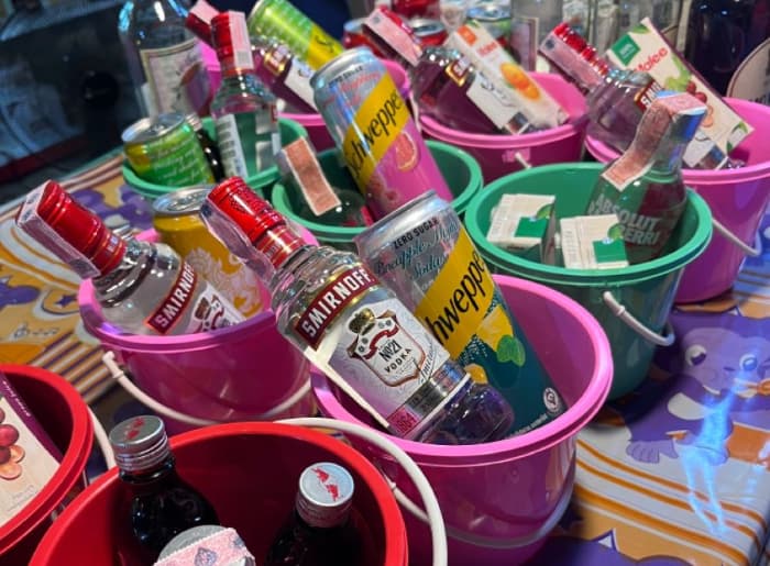 Colorful Thai bucket drinks filled with alcohol, ice, and straws, popular among tourists at Thailand's Full Moon Parties.