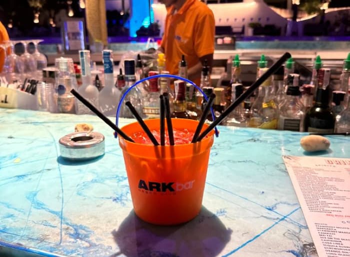 Colorful Thai bucket drinks filled with alcohol, ice, and straws, popular among tourists at Thailand's Full Moon Parties.