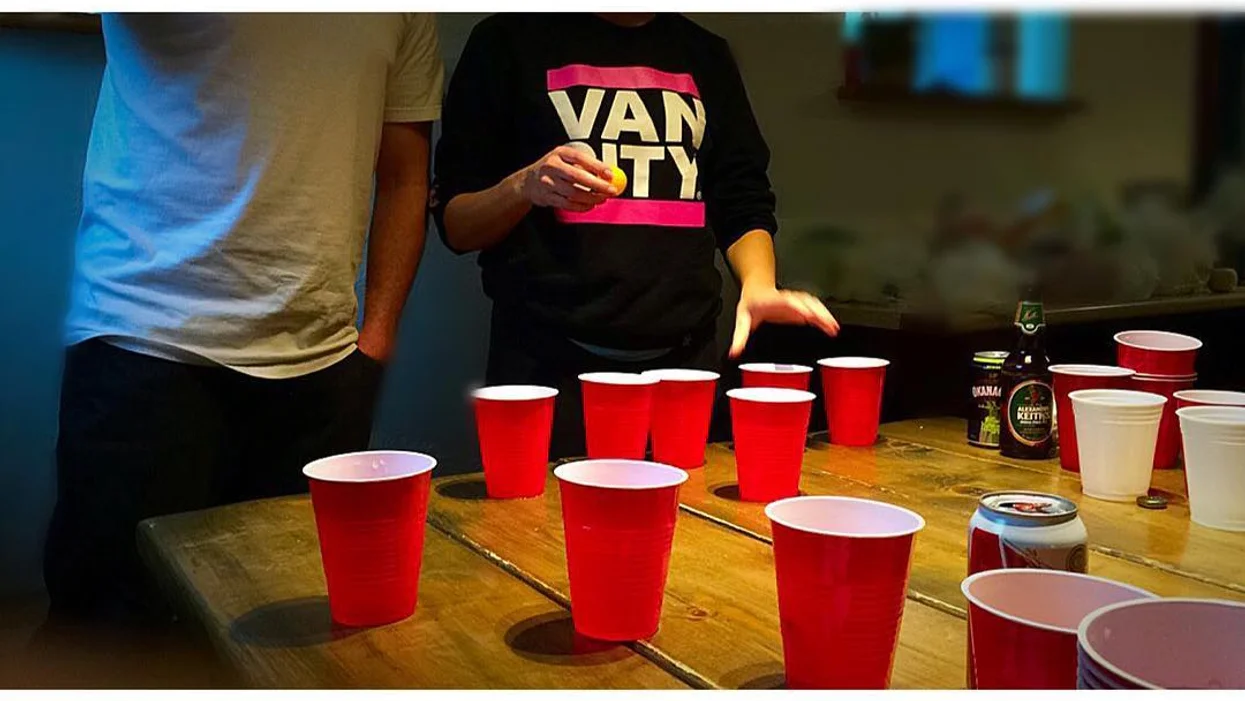 Some plastic cups on a table, set up for a game of beer pong. It's something a first-time drinker would enjoy!