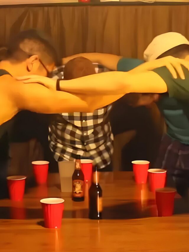 A group of friends arm-in-arm in a circle over glasses of alcohol.