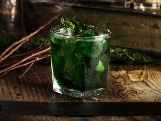 Dark green cocktail with mint leaves, looks like those mushy cocktails inspired by classic horror villains