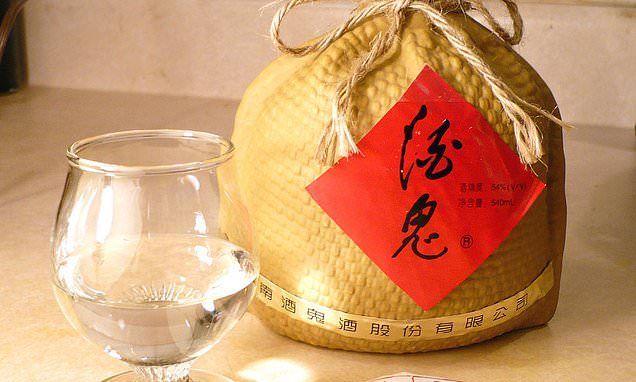 A bag of grain adjacent to a glass filled with baijiu 