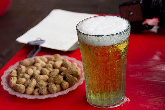 A glass of Bia Hoi- the world's cheapest beer, served with peanuts.