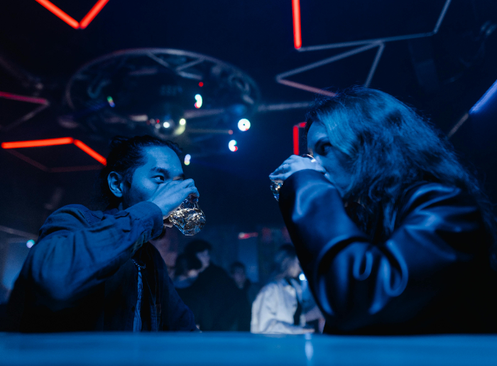 A boy and a girl drinking at the bar